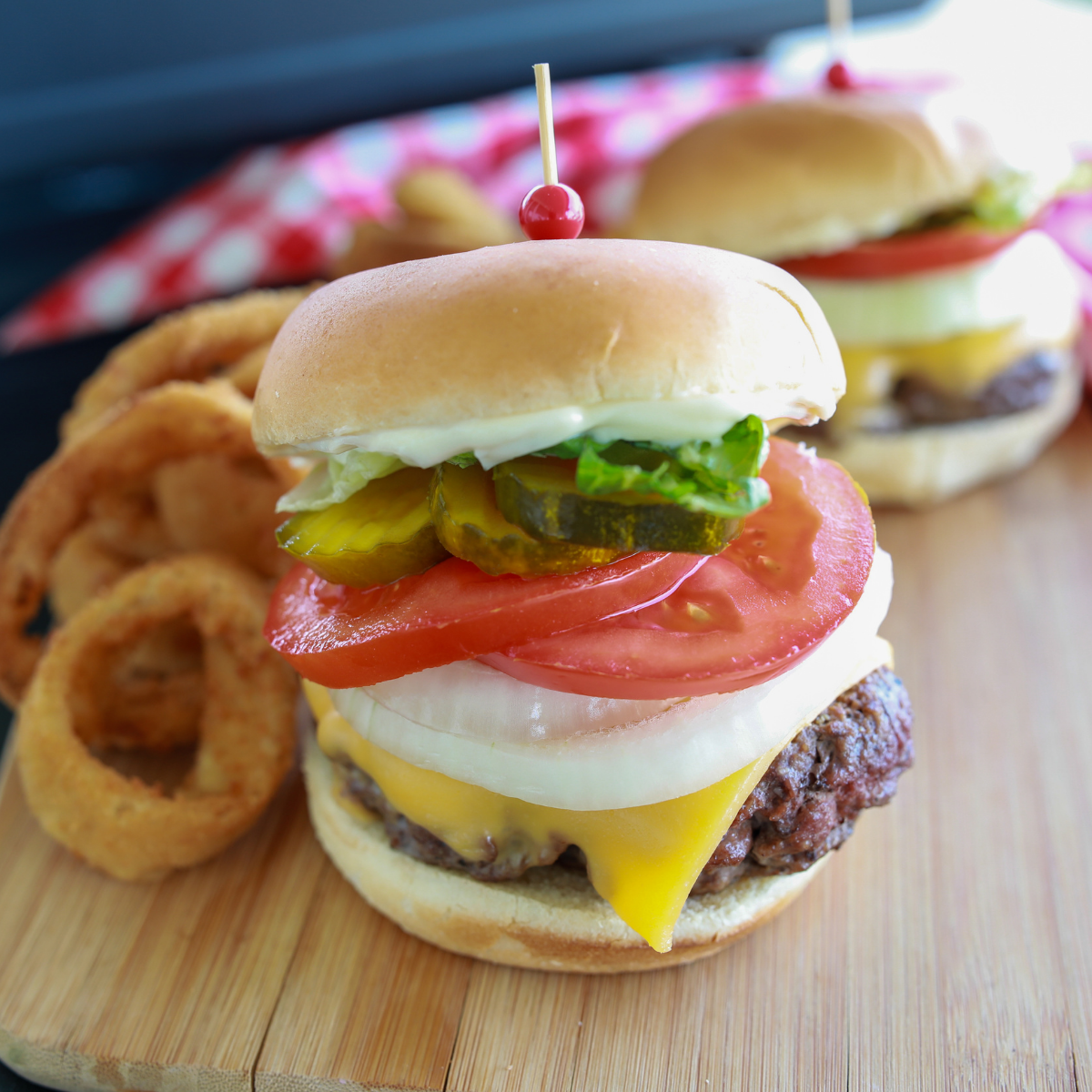 Blackstone smash burgers assembled on toasted buns with fresh toppings and melted cheese ready to serve