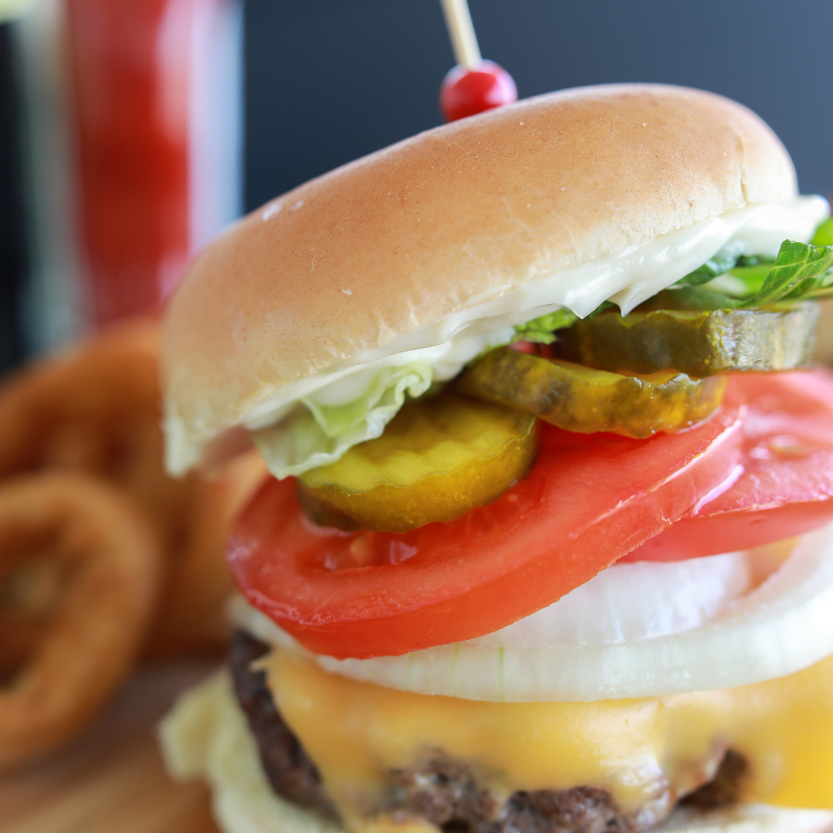 Two crispy-edged Blackstone smash burgers stacked on toasted brioche buns with melted American cheese