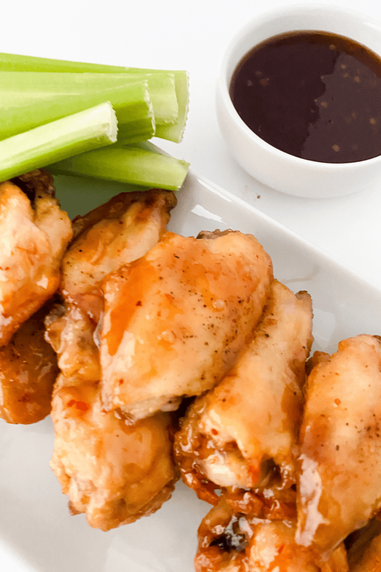 Plate of crispy chicken wings coated in sweet and tangy Hawaiian sauce, served hot and ready to enjoy.