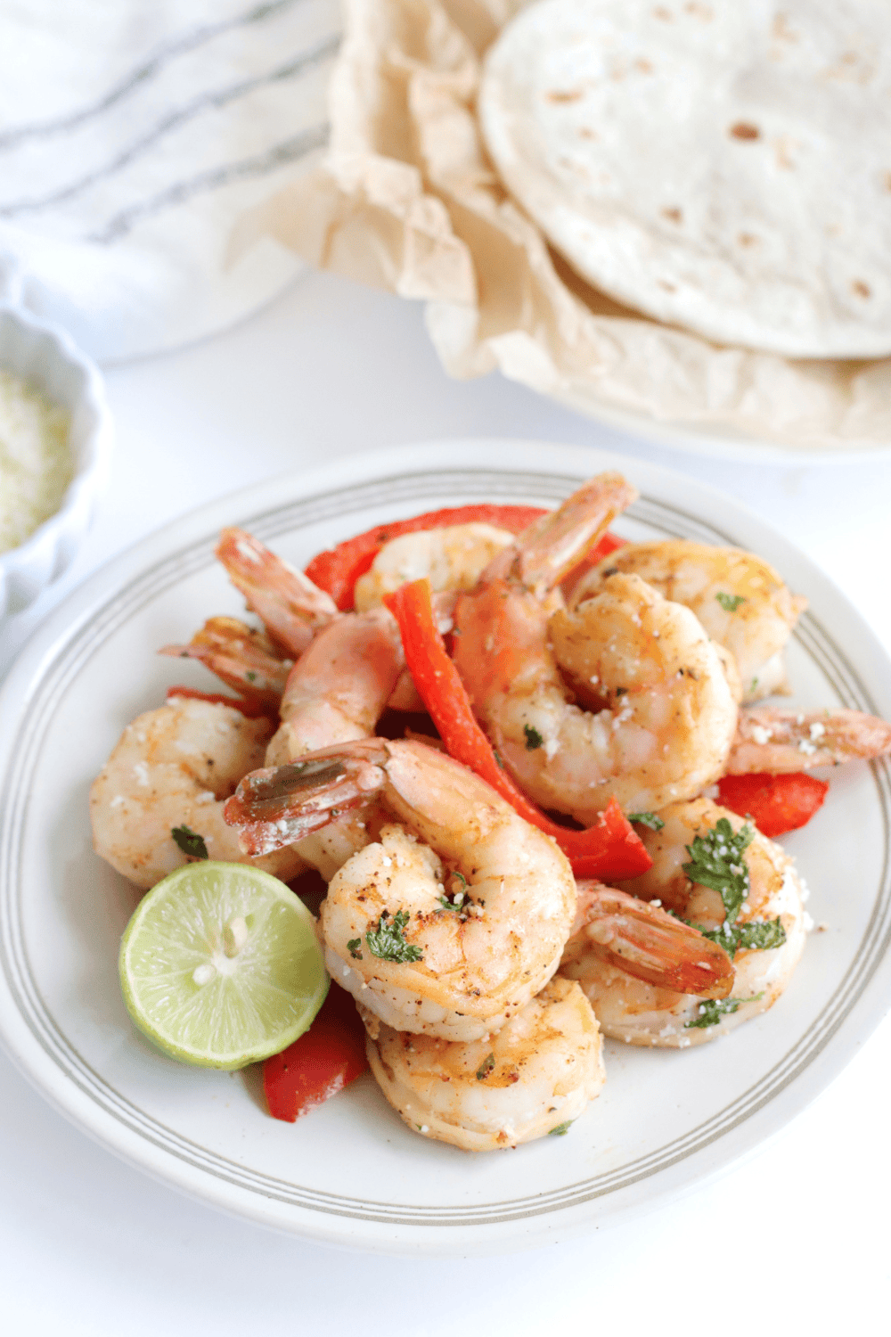 Air fryer shrimp fajitas with saut&eacute;ed bell peppers and onions on a plate.