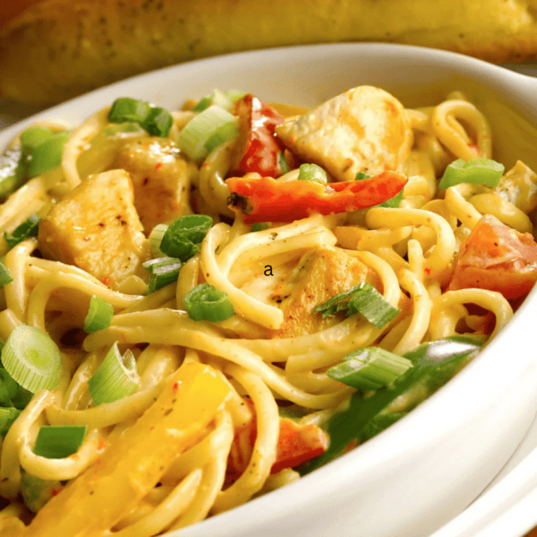 Instant Pot Chicken Fajita Pasta in a bowl with creamy sauce, sliced chicken, bell peppers, and pasta coated in fajita seasoning.