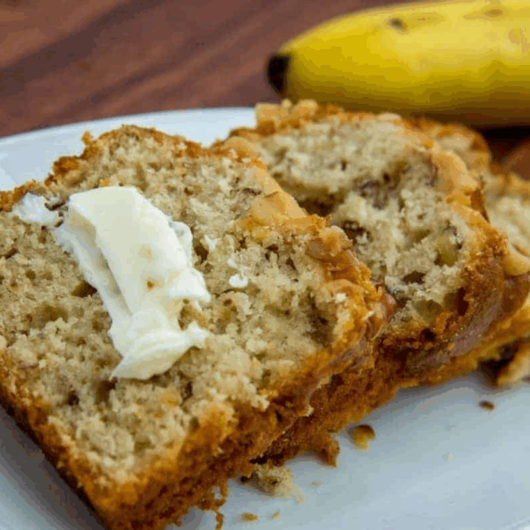 Sliced air fryer banana walnut pound cake with golden crust and walnuts.