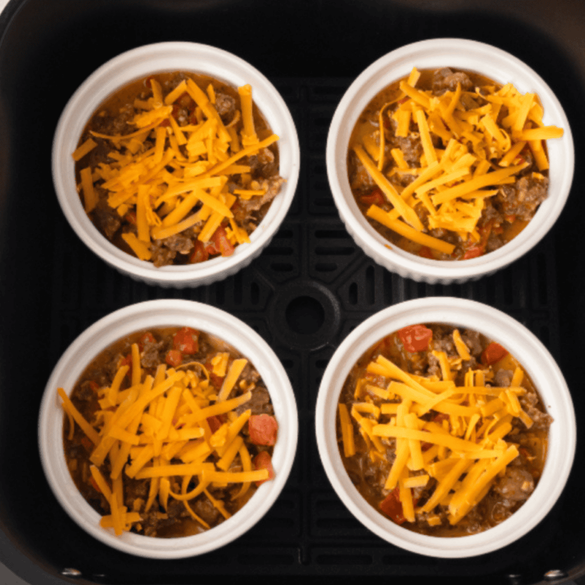 Closeup of 4 egg bakes in the air fryer basket