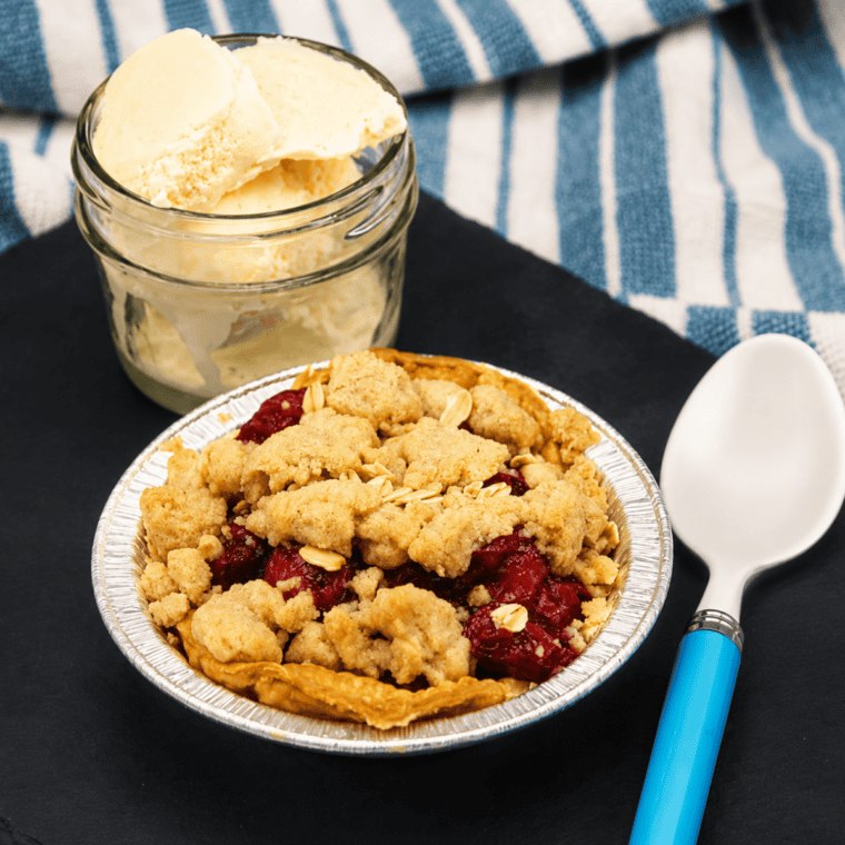 Air fryer cherry crumb pies served on plates with vanilla ice cream