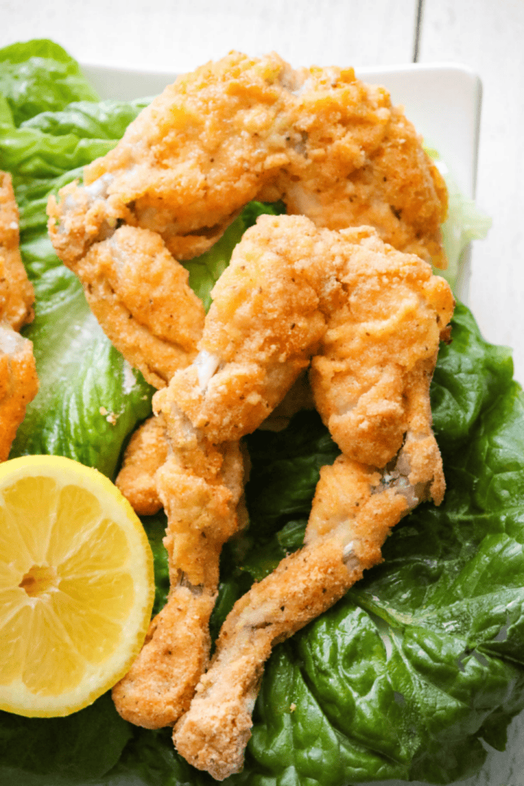 Crispy golden-brown air fryer frog legs on a plate, cooked to tender perfection with a crunchy coating.
