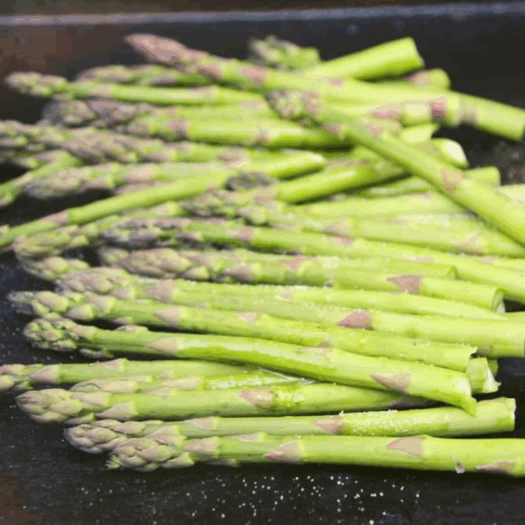 Place seasoned asparagus on the Blackstone griddle.