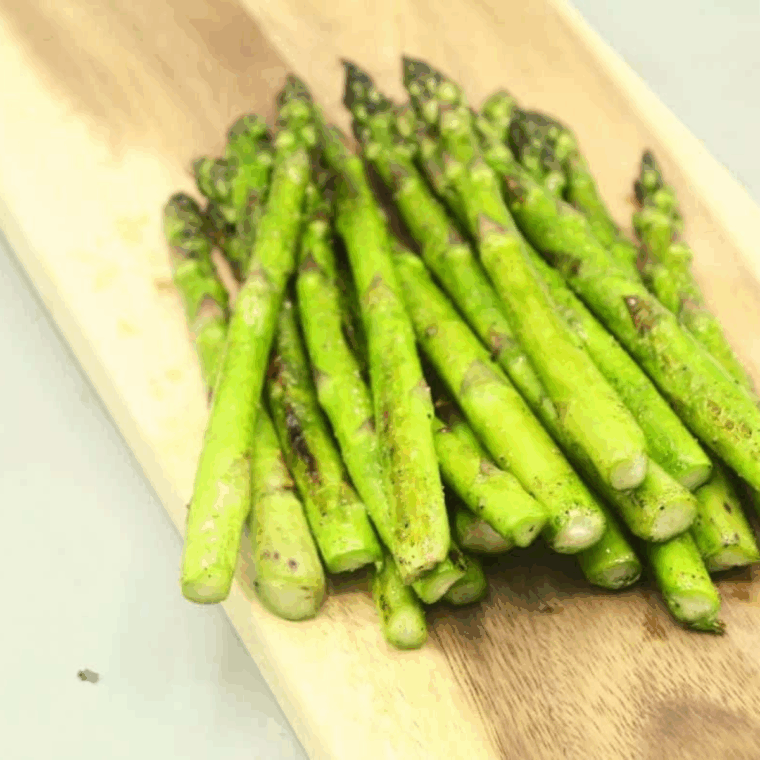 Cooked Blackstone Griddle Asparagus on cutting board.