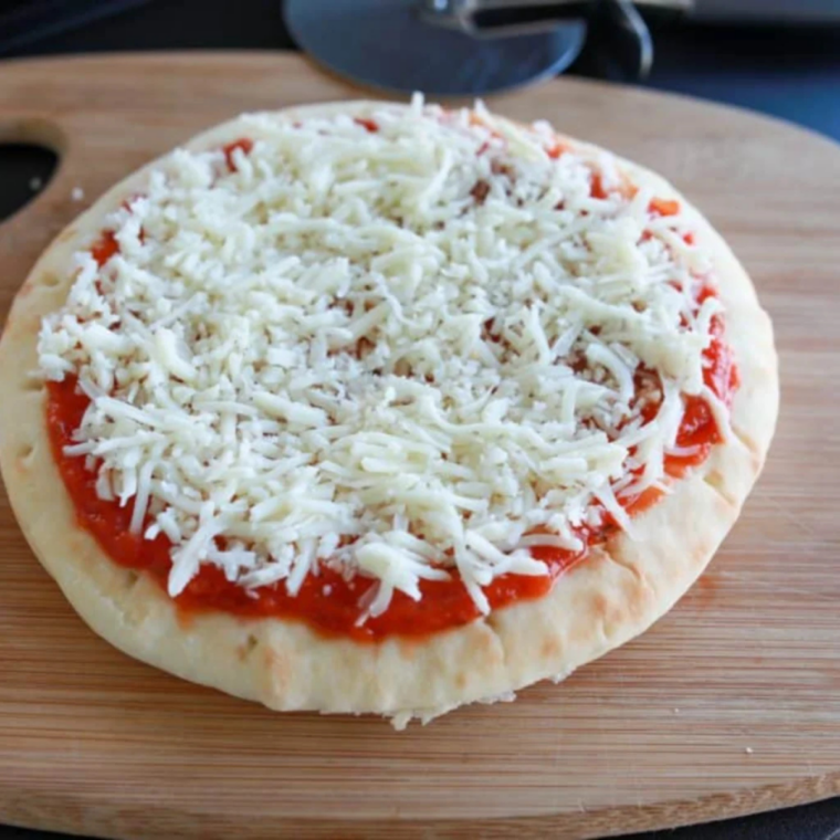 Adding the cheese on top of the pizza.