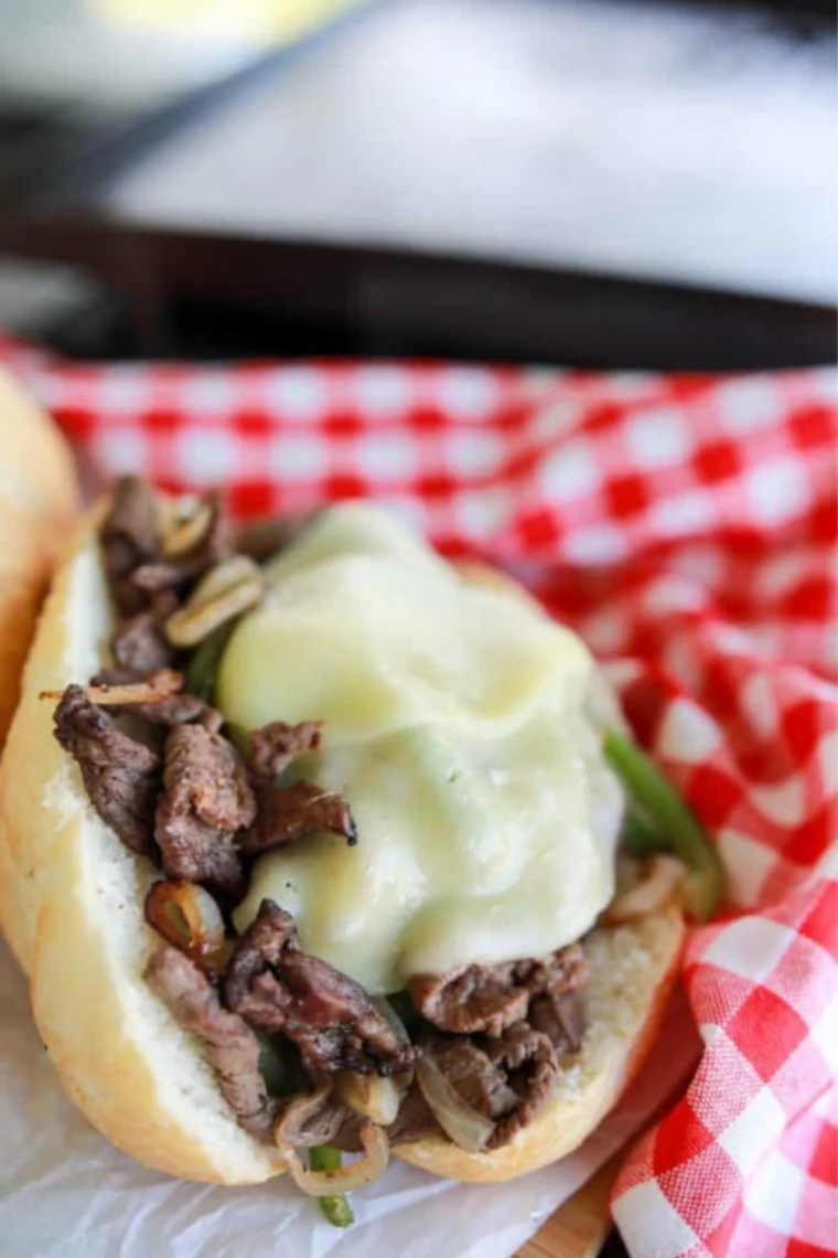 Blackstone Philly Cheesesteak loaded with sliced steak, onions, peppers, and melted provolone cheese on a toasted hoagie roll.