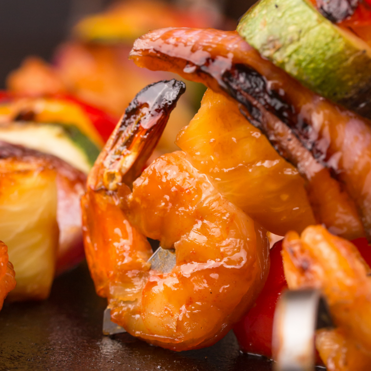 Blackstone garlic butter shrimp sizzling on griddle with lemon and parsley