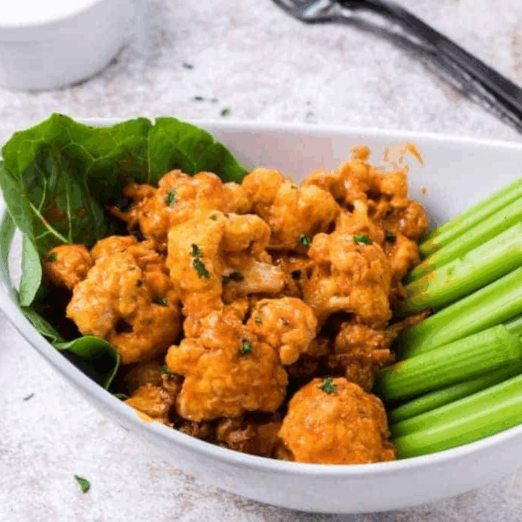 Air fryer Copycat Buffalo Wild Wings Buffalo Cauliflower Bites coated in spicy buffalo sauce, ready to serve.