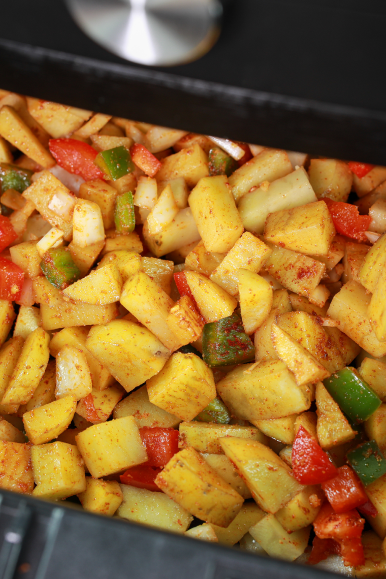 Season cubed potatoes with oil and spices, toss until fully coated