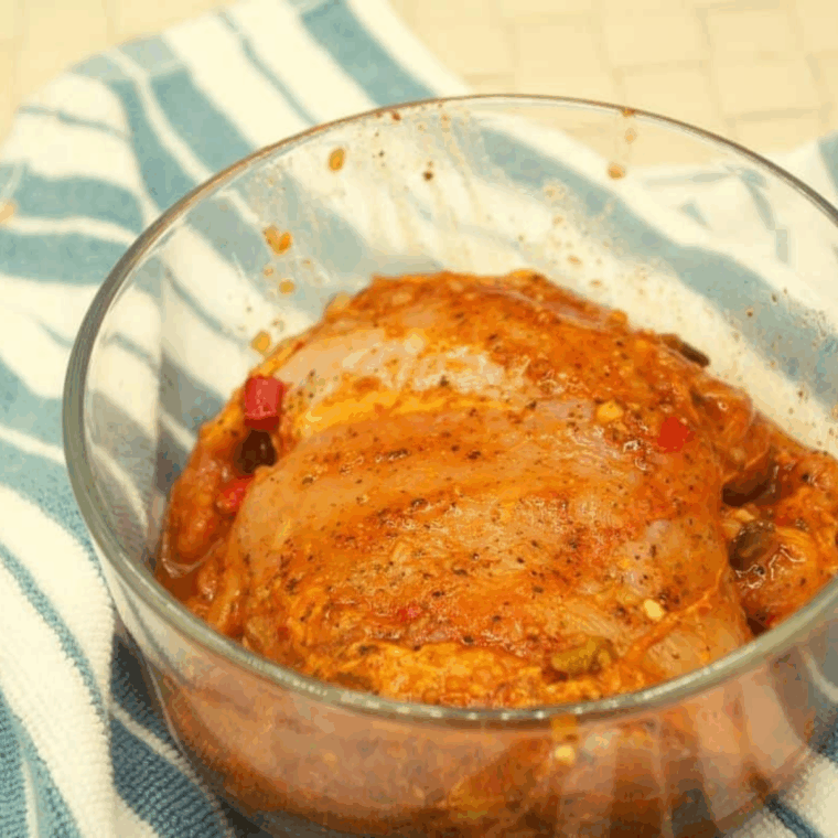 Marinate chicken thighs in olive oil, lime juice, orange juice, and adobo seasoning, then refrigerate for two hours.