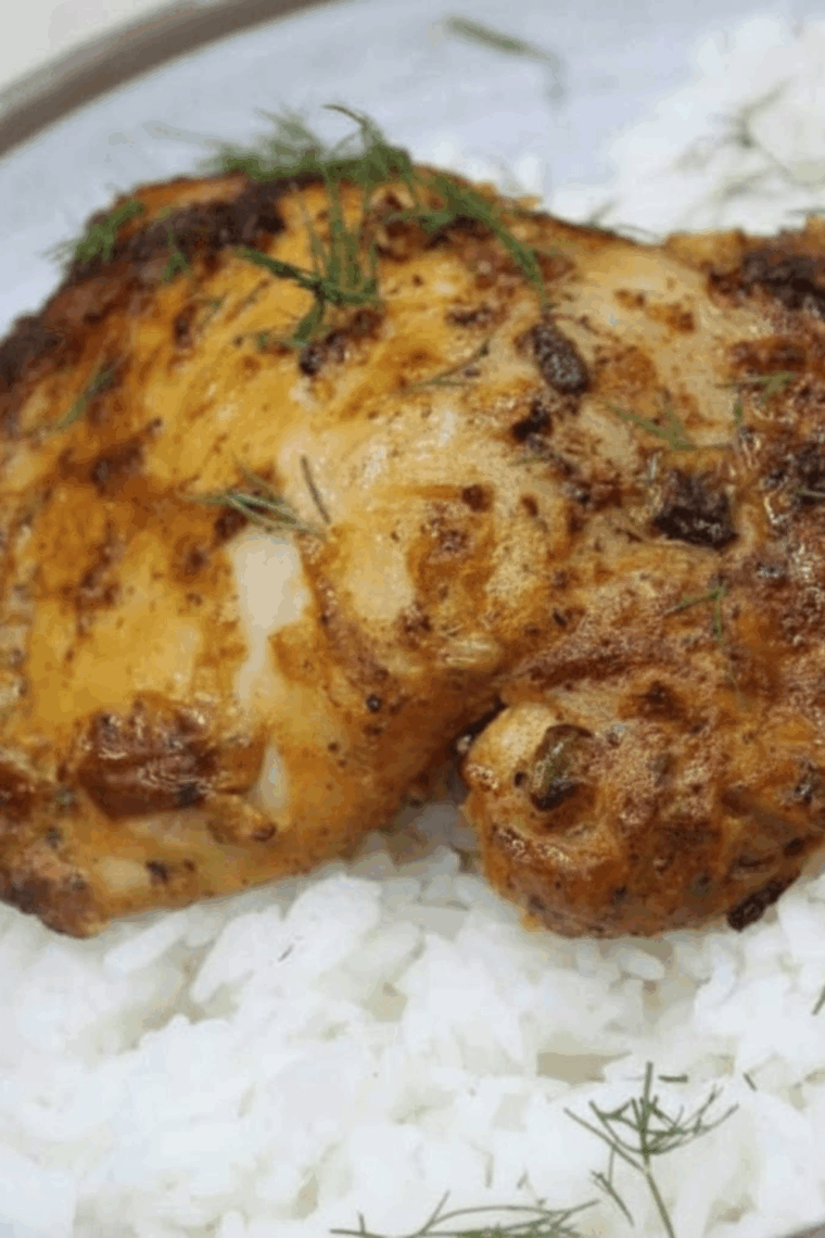 Air fryer basket with marinated pollo asado chicken thighs cooking to golden perfection.