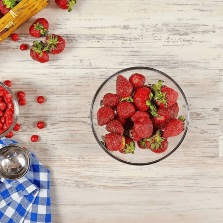 Fresh strawberries sliced and quartered in a small bowl, ready for use.