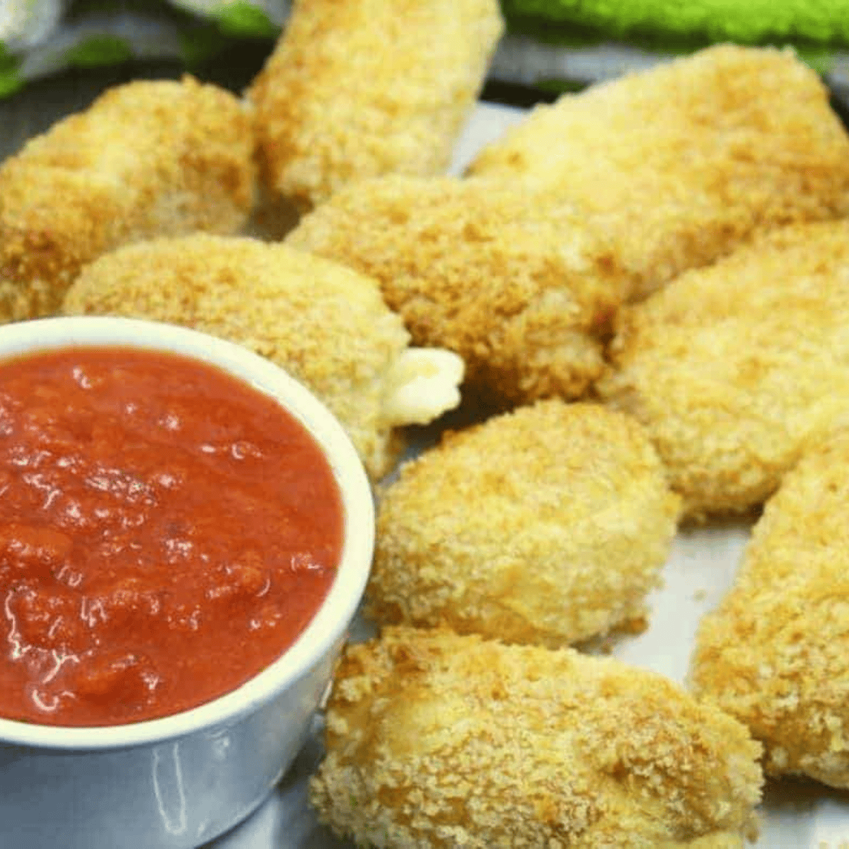 Golden, crispy 4-Ingredient Air Fryer Mozzarella Bites served with a side of marinara sauce.