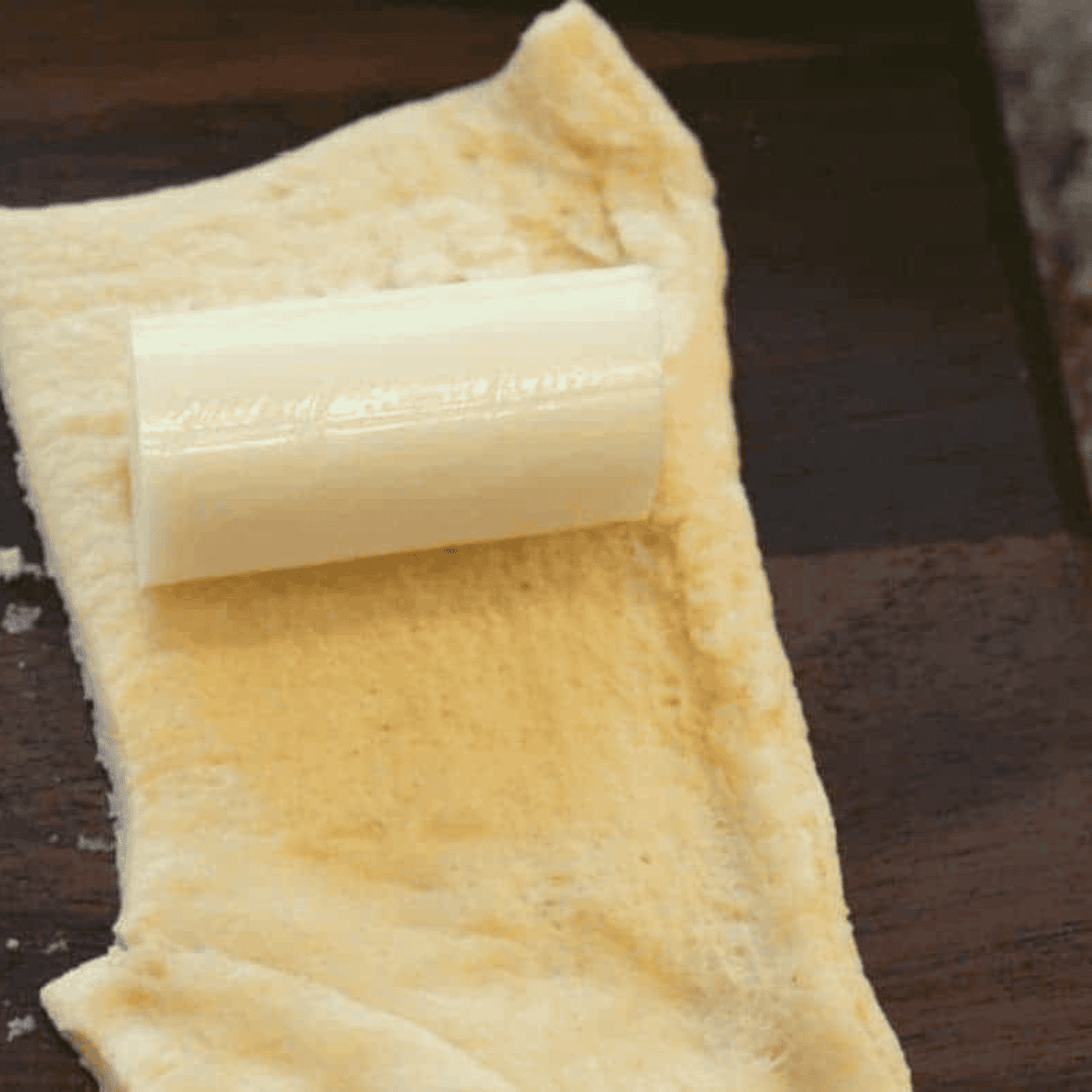 Place the cheese stick into the dough.