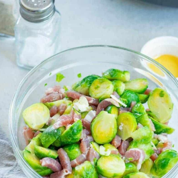 Halved Brussels sprouts, chopped bacon, garlic, olive oil, salt and pepper tossed together in a large bowl