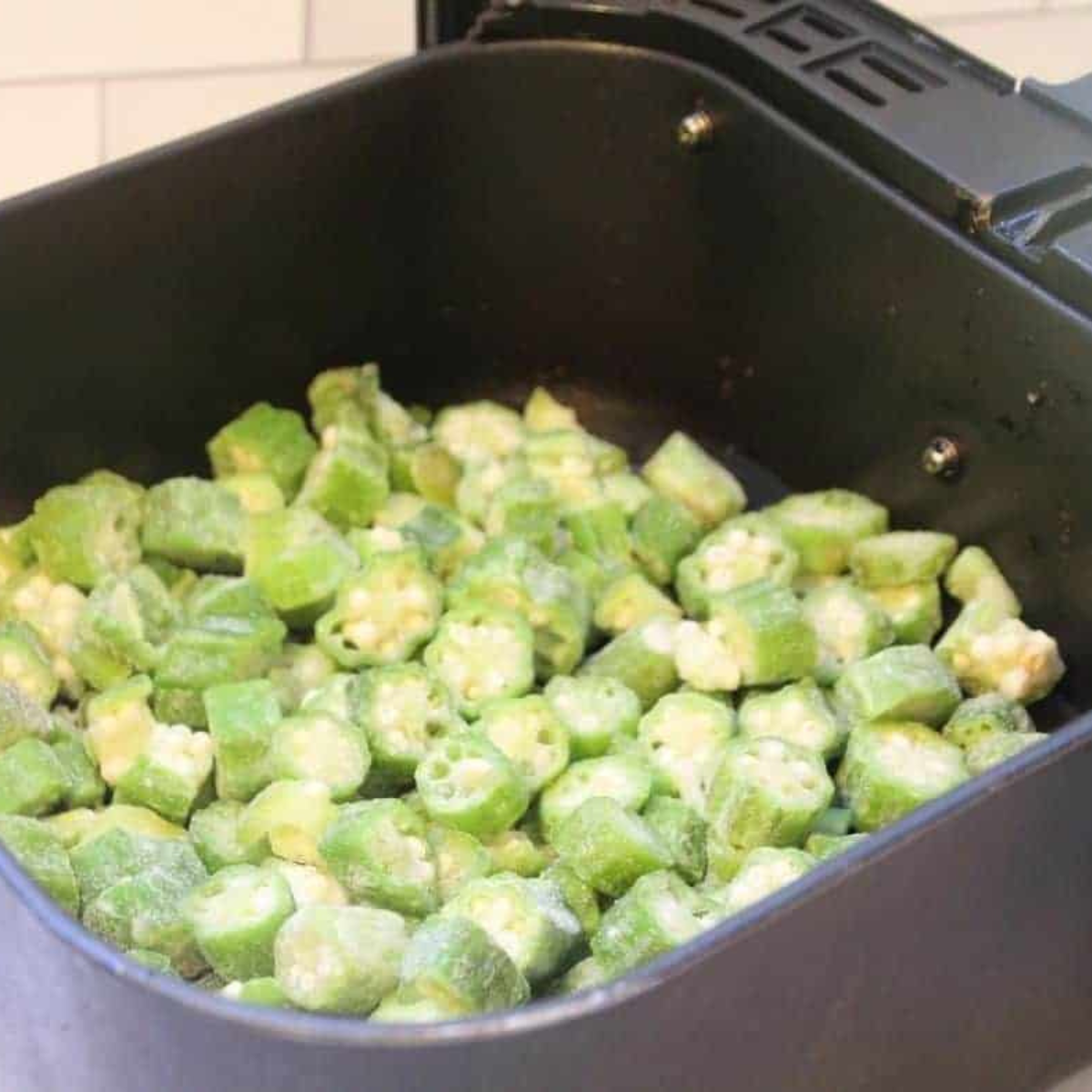 Frozen okra spread in a single layer in an air fryer basket