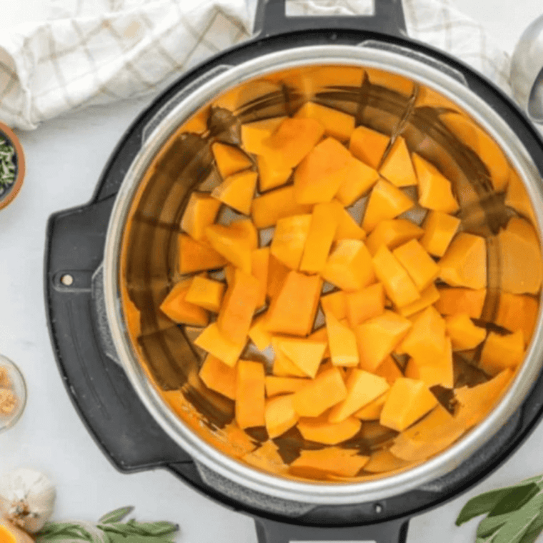 Cubed butternut squash and sweet potato stirred into sautéed onions in the Instant Pot