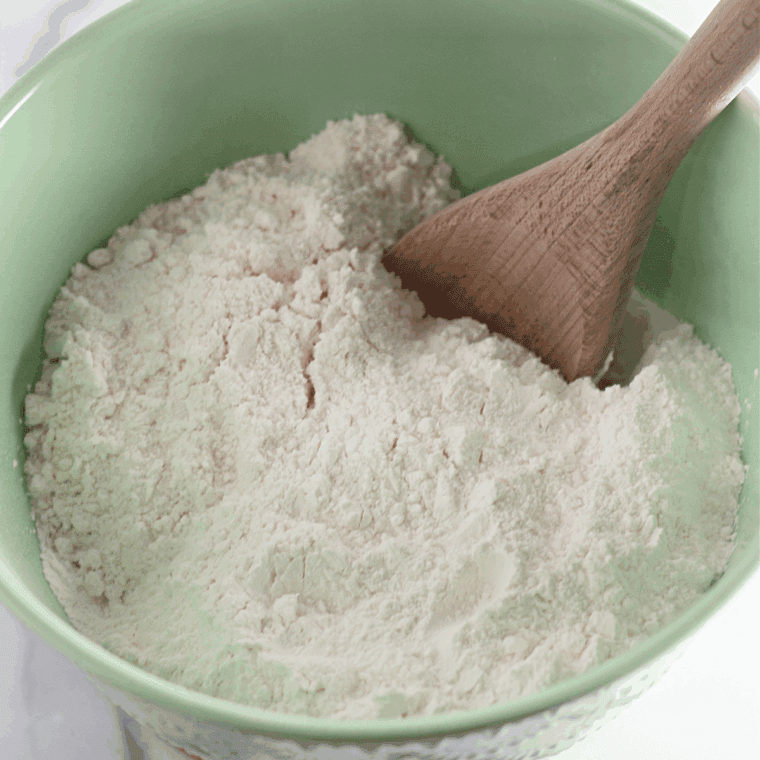 Small bowl with angel food cake mix, water, and vanilla being mixed until smooth