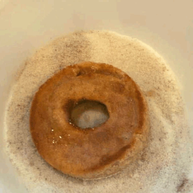 Dipping the banana donuts into the coating.