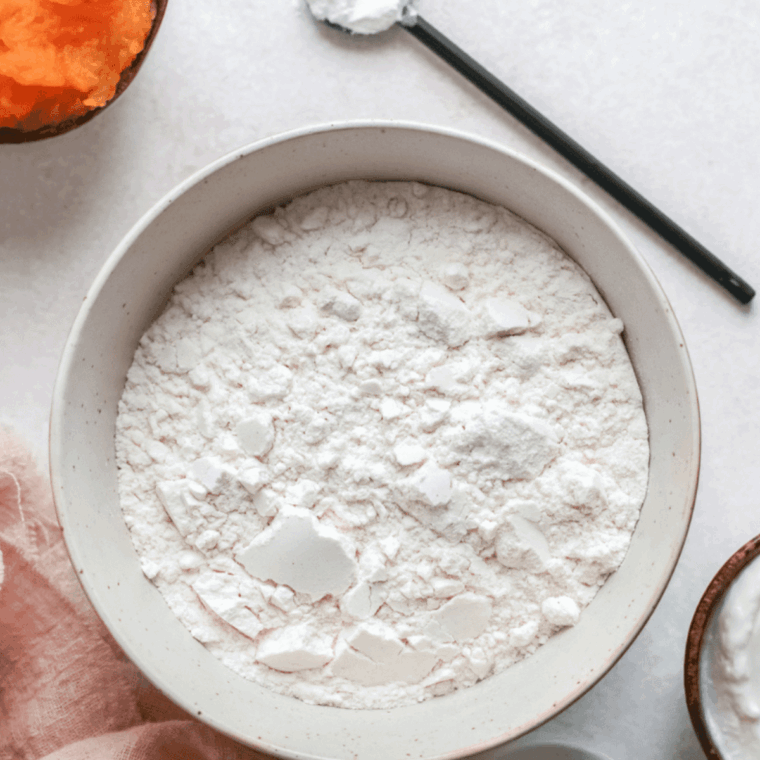 Mixing dry ingredients in one bowl and creaming butter, sugar, eggs, bananas, vanilla, and sour cream in another for banana donut batter.