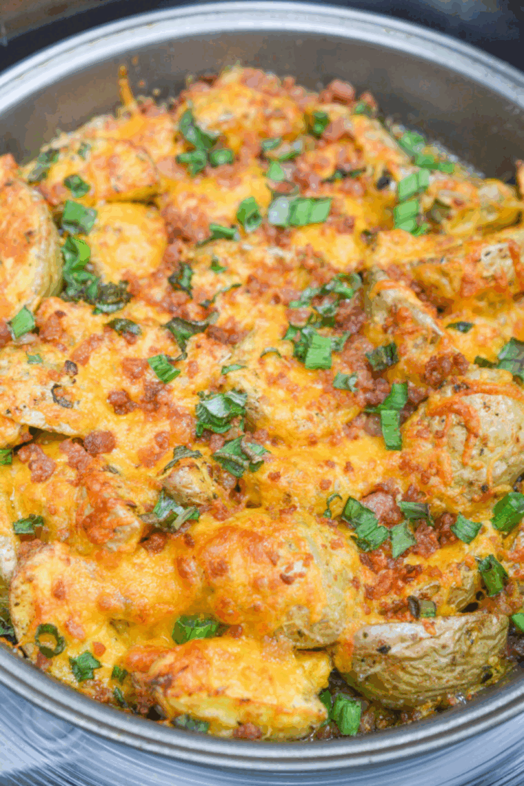 Crispy air fryer loaded baby potatoes garnished with parsley and grated Parmesan, ready to serve.
