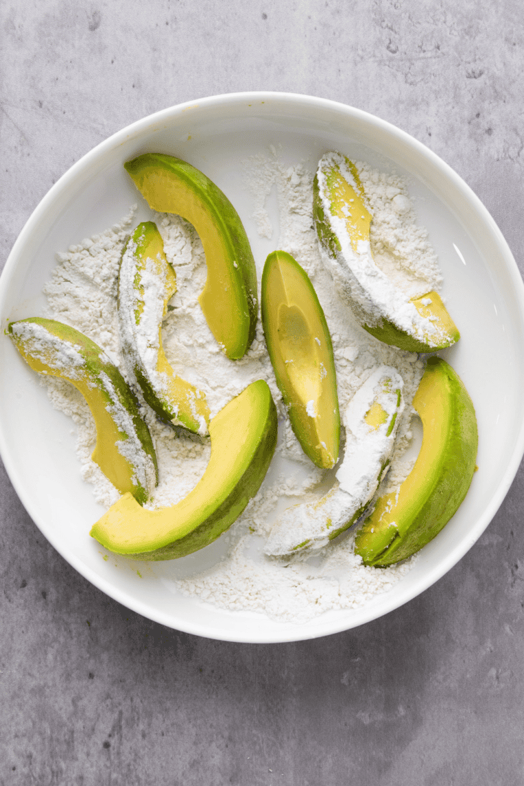 avocado fries being lightly coated with gluten-free flour for crispiness
