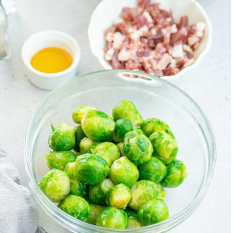 Bowl of air fryer frozen Brussels sprouts with crispy bacon on the side