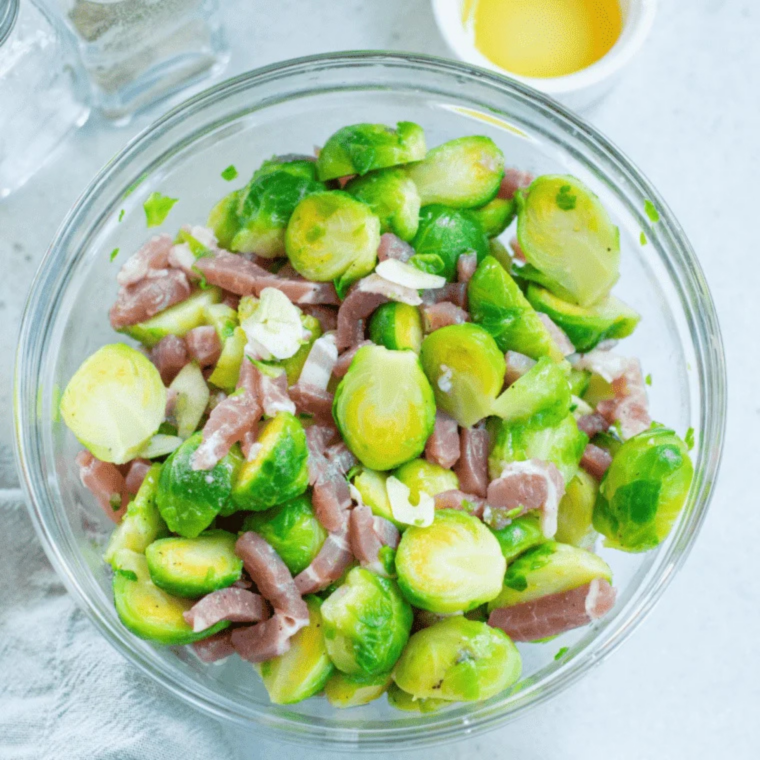 Frozen Brussels sprouts spread in a single layer in an air fryer basket