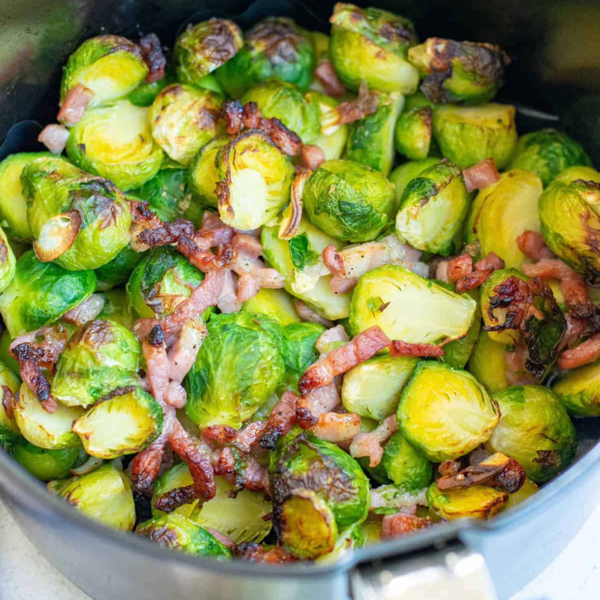 Close-up of crispy, golden-brown air fryer frozen Brussels sprouts showing the browned outer leaves