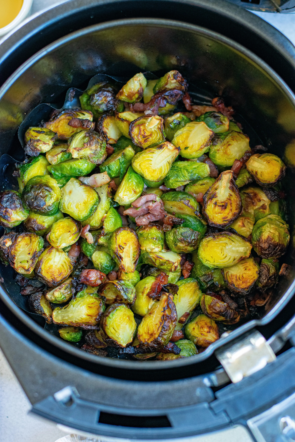 Crispy golden Brussels sprouts in the air fryer basket after cooking from frozen