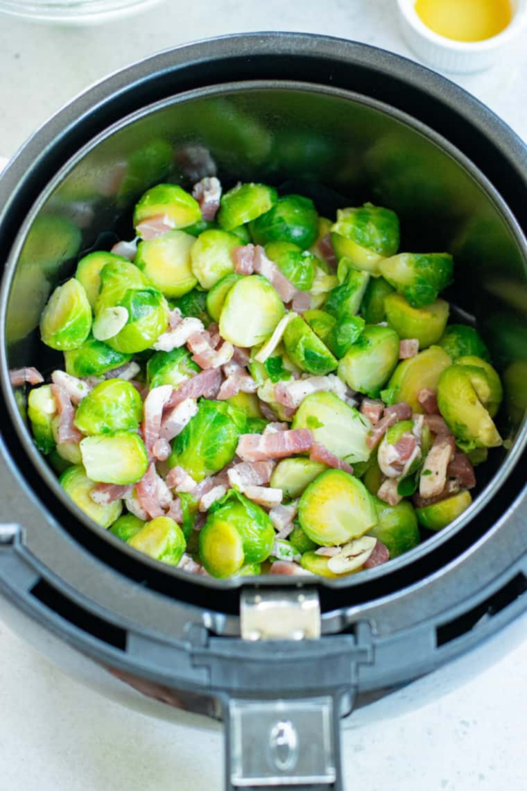 Frozen Brussels sprouts spread in a single layer in an air fryer basket