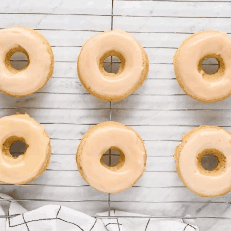 Air fryer maple frosted donuts on a wire rack, golden brown and glazed with maple icing.