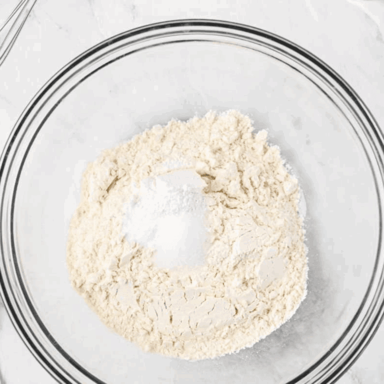 Mixing dry ingredients—flour, salt, baking powder, and baking soda—in a large bowl for donut batter.