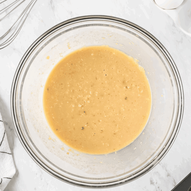Whisking together sugar, butter, egg, vanilla, maple extract, buttermilk, and maple syrup in a mixing bowl.