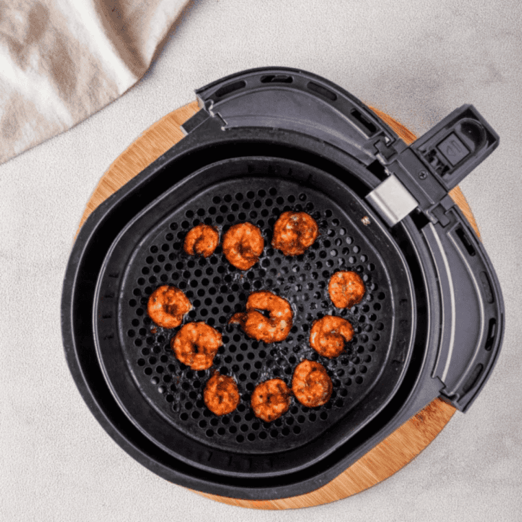 Cooked air fryer Old Bay shrimp skewers on a platter with lemon wedges and melted butter
