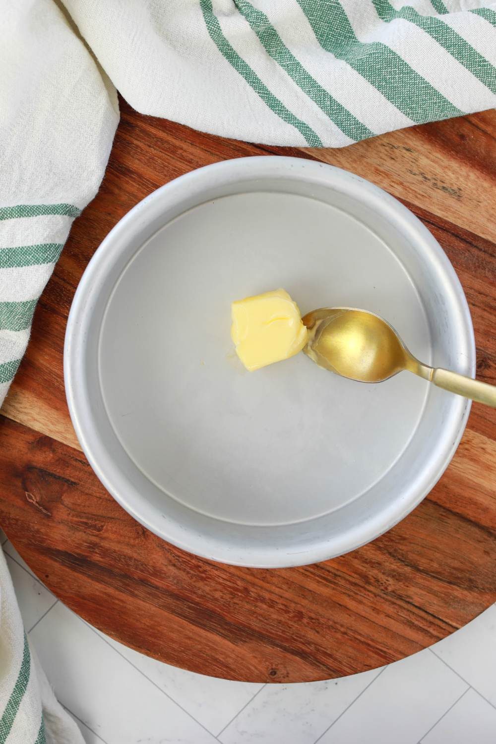 butter melting in pan inside air fryer during preheat to prevent sticking