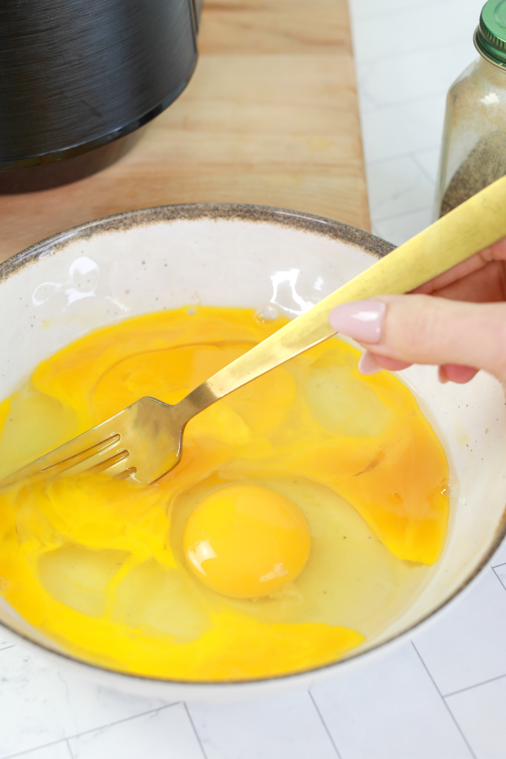 whisking eggs with milk salt and pepper until smooth and frothy.