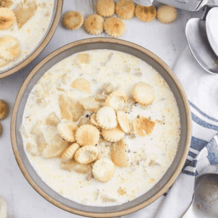 Bowl of creamy Progresso-style New England Clam Chowder with clams, potatoes, and crispy bacon on top.