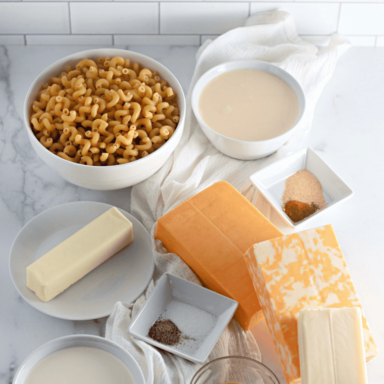 Ingredients for copycat Costco mac and cheese including cavatappi pasta, cheddar, Pecorino Romano, Parmigiano-Reggiano, butter, cream, and seasonings