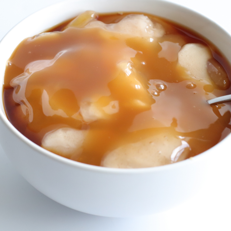 Apple pie filling, caramel sauce, and apple pie spice stirred together in a glass bowl