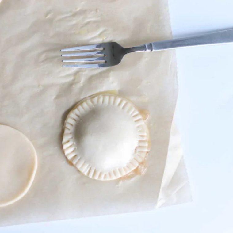 Crimping the edges of an air fryer caramel apple hand pie with a fork