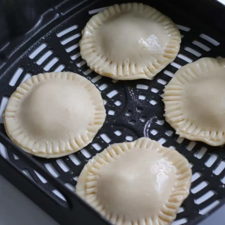 Air Fryer Caramel Apple Hand Pies arranged in a single layer in the air fryer basket