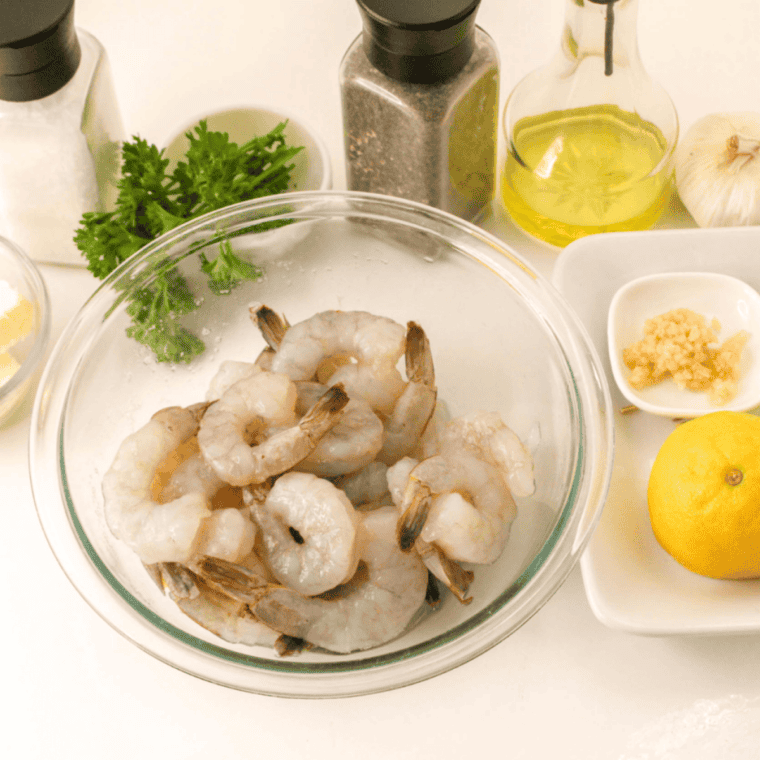 Ingredients for air fryer garlic butter shrimp: raw shrimp, butter, garlic, lemon, parsley, and seasoning.