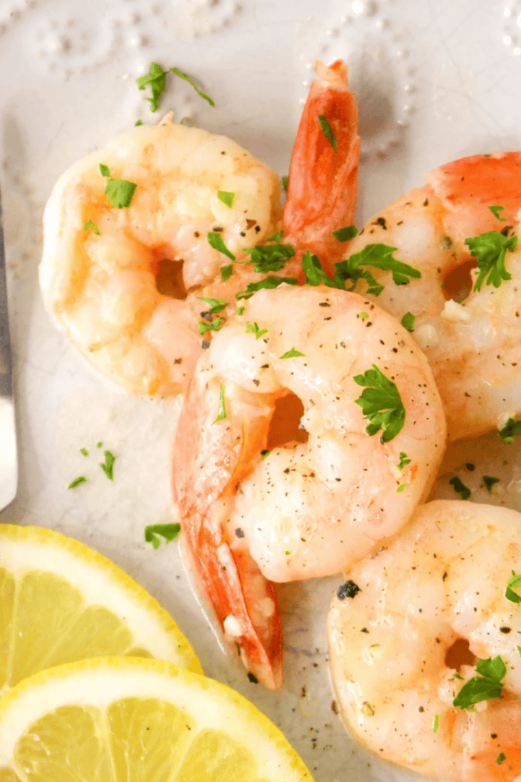 Air fryer garlic butter shrimp in basket, golden crispy shrimp tossed in melted garlic butter, quick 15 minute seafood recipe served hot and garnished with parsley