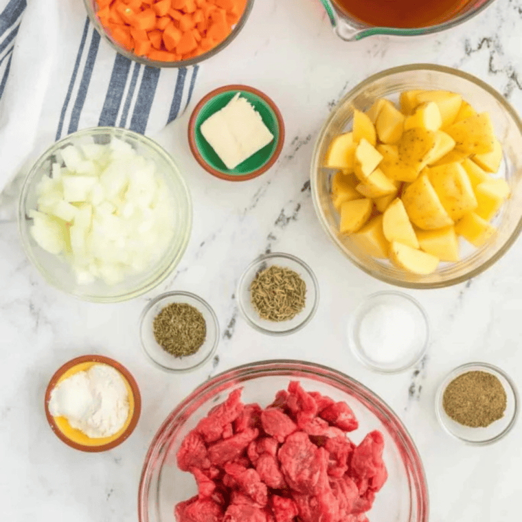 alt tag for piture of ingreint on table
Ingredients for Panera Bread beef stew copycat including beef stew meat, carrots, celery, potatoes, onion, garlic, beef broth, and herbs on a table