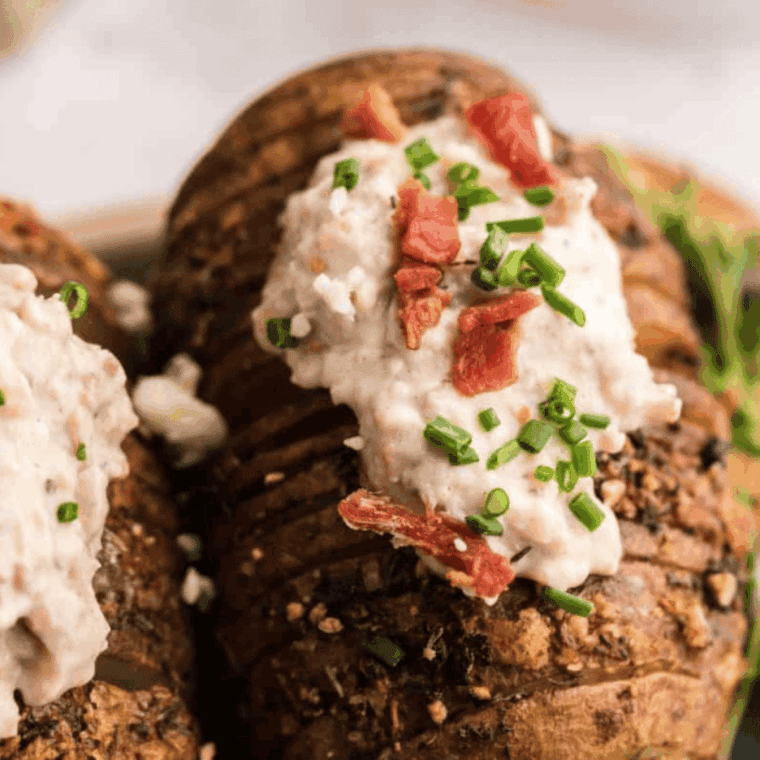 Crispy Hasselback potatoes cooked in the air fryer, topped with bacon and melted bleu cheese