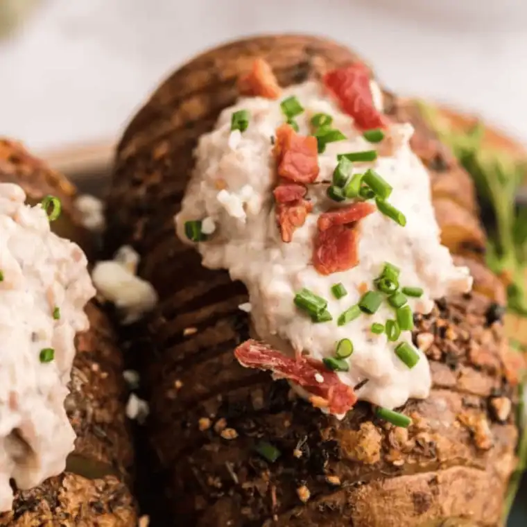 Golden Hasselback potatoes topped with crispy bacon, melted bleu cheese, and fresh chives